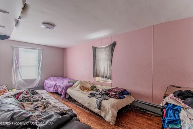 a bedroom with two bed and a window