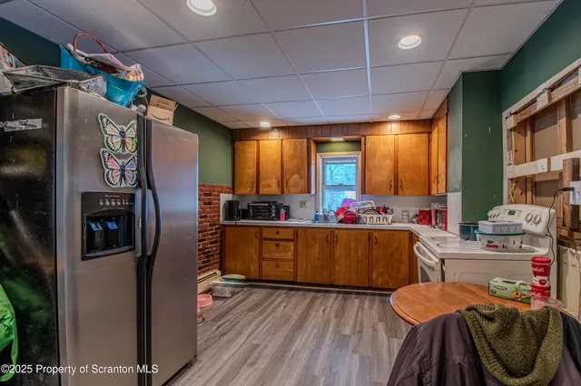 a kitchen with stainless steel appliances wooden floor dining table and chairs