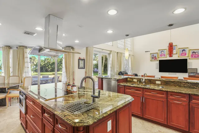 a kitchen with granite countertop a sink and a wooden floor