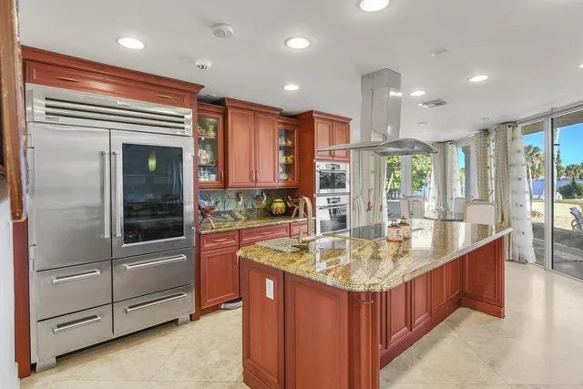 a kitchen with kitchen island sink and refrigerator