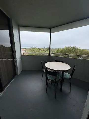 a balcony with table and chairs