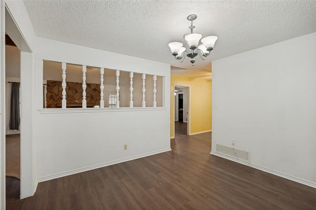 508 South Pedigo Street Pilot Point, TX 76258 - Photo 7 of 26 Spacious dining room featuring wood-finish flooring, light gray walls, and a window with gray drapes