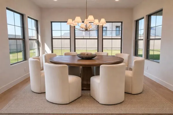 a dining room with furniture a large window and a chandelier