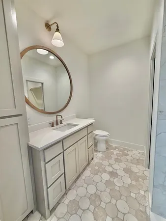 a bathroom with a toilet sink and mirror