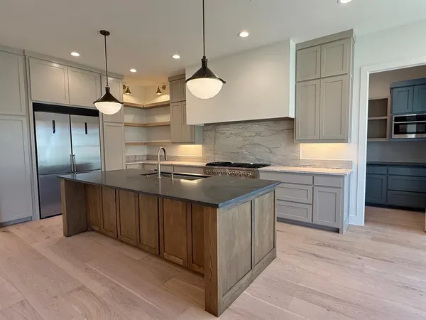 a kitchen with kitchen island granite countertop a sink and stainless steel appliances