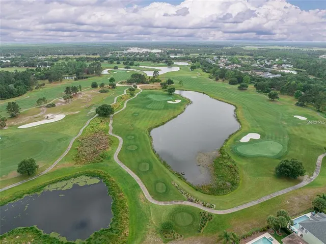 an aerial view of a golf course with a swimming pool