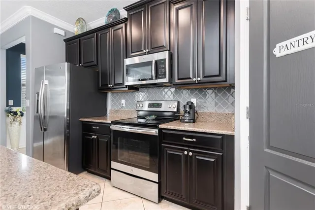 a kitchen with stainless steel appliances granite countertop a stove microwave and refrigerator