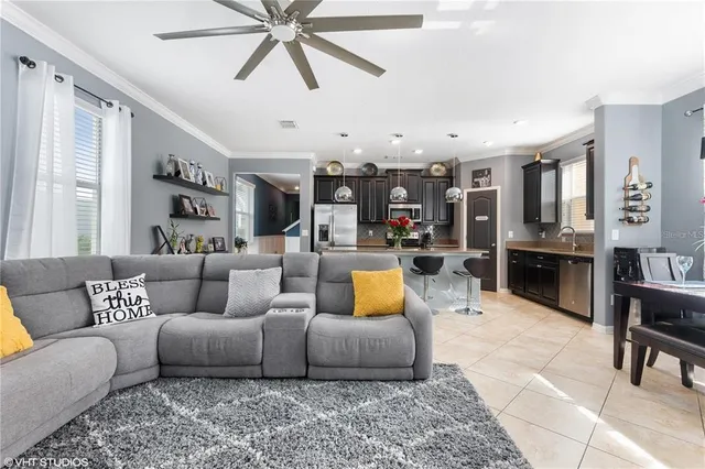 a living room with furniture kitchen view and a chandelier