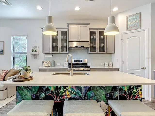 a kitchen with stainless steel appliances granite countertop white cabinets and a stove