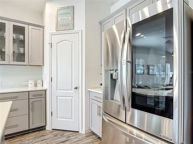 a kitchen with a stove a sink a dining table and chairs with wooden floor