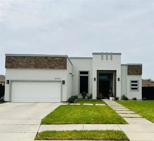 a view of a house with a yard and garage