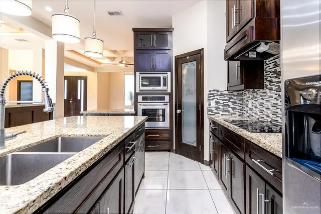 a kitchen with stainless steel appliances granite countertop a sink stove and refrigerator