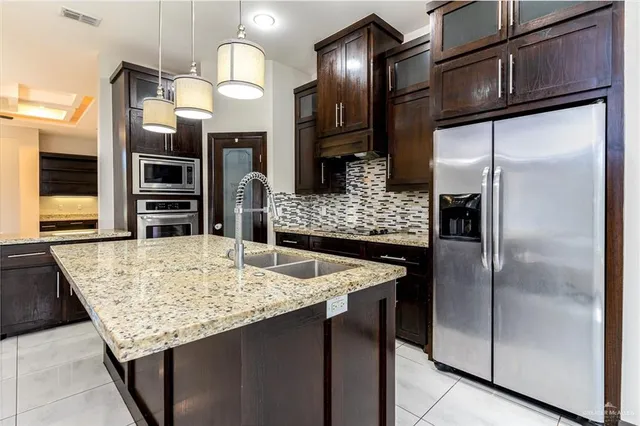 a kitchen with stainless steel appliances granite countertop a refrigerator and a sink