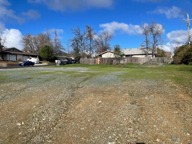 an aerial view of a house with a yard and a large parking space