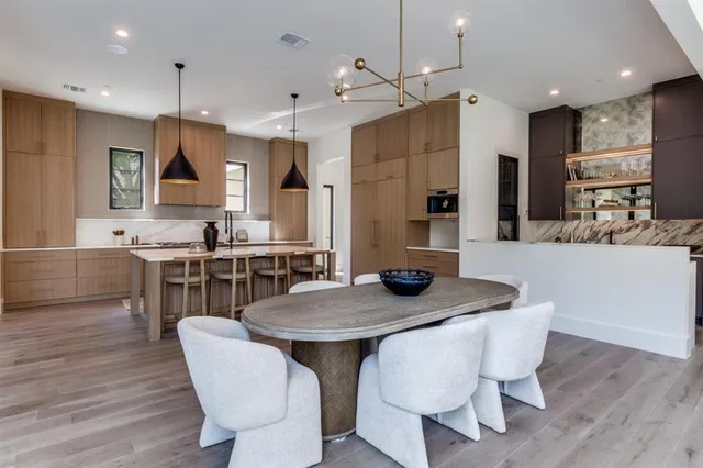 a kitchen with stainless steel appliances granite countertop a stove a kitchen island a dining table and chairs