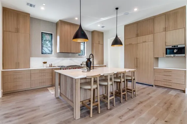 a kitchen with kitchen island granite countertop a sink counter and chairs
