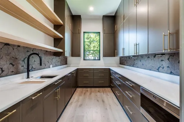 a large kitchen with a sink and large window