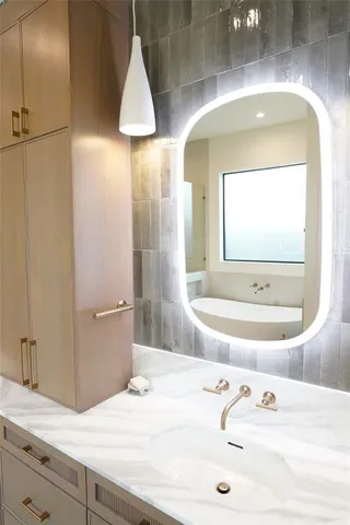 a bathroom with a granite countertop sink and a mirror