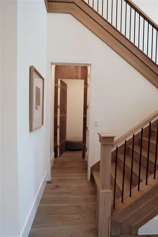 a view of a hallway with wooden floor and staircase