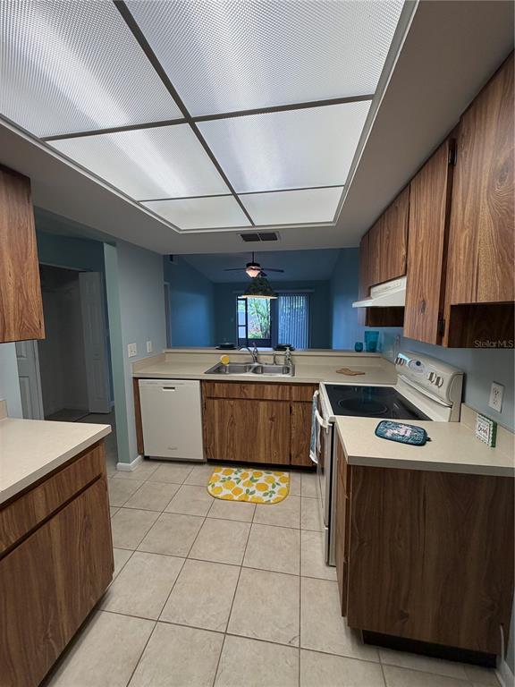 2131 Ridge Road South, Unit 135 Largo, FL 33778 - Photo 16 of 33 a kitchen with stainless steel appliances granite countertop a stove a sink dishwasher and a refrigerator