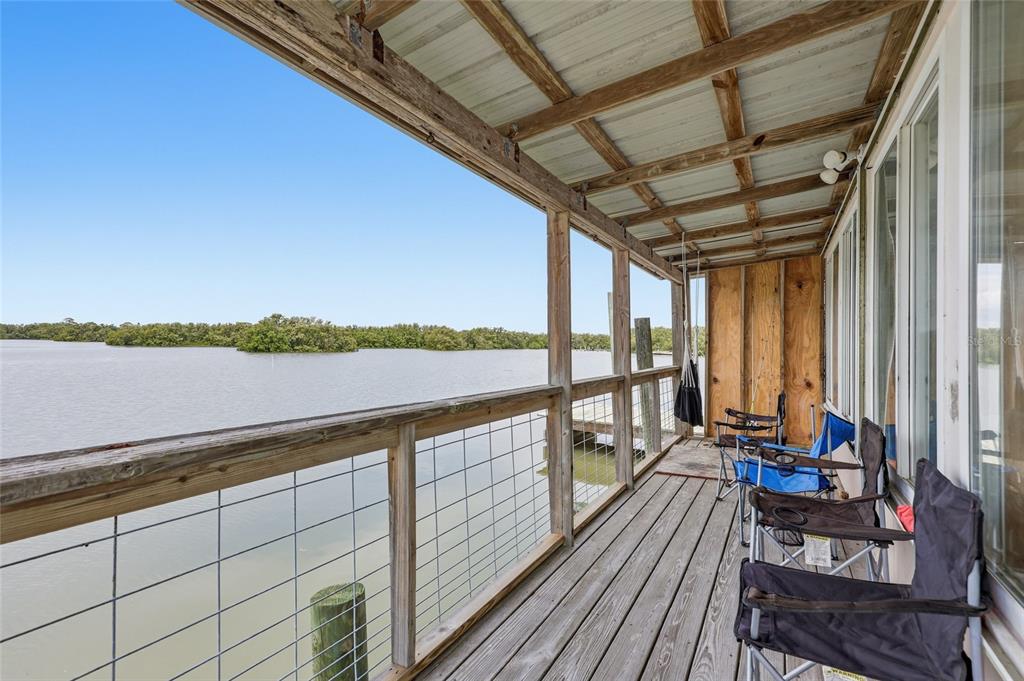 505 3rd Street Cedar Key, FL 32625 - Photo 19 of 37 a view of balcony with couch and wooden floor