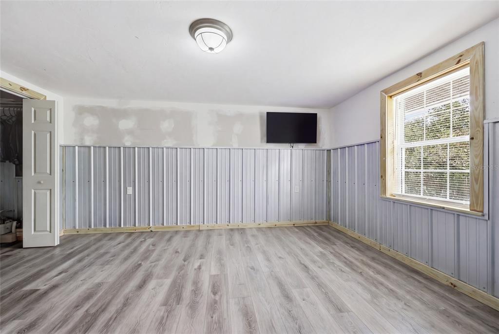 505 3rd Street Cedar Key, FL 32625 - Photo 8 of 37 an empty room with wooden floor and windows