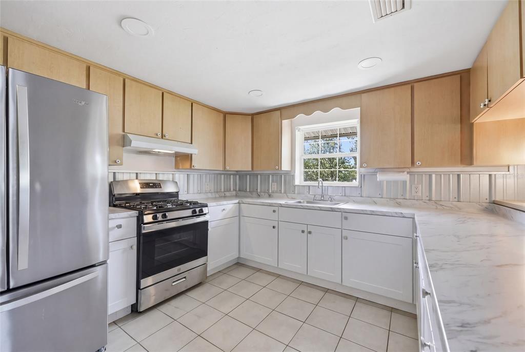 505 3rd Street Cedar Key, FL 32625 - Photo 9 of 37 a kitchen with granite countertop a sink stainless steel appliances and cabinets