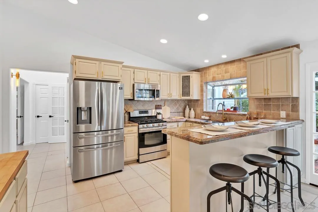 12731 Stone Canyon Road Poway, CA 92064 - Photo 11 of 44 a kitchen with white cabinets and stainless steel appliances