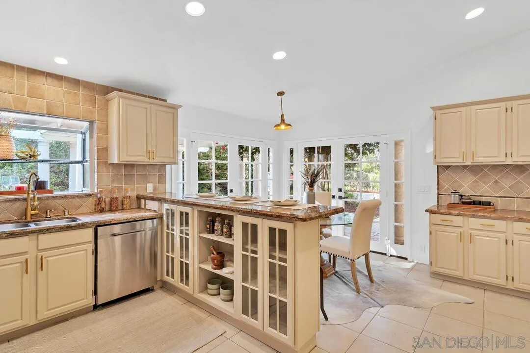 12731 Stone Canyon Road Poway, CA 92064 - Photo 12 of 44 a kitchen with a stove a sink a dining table and chairs