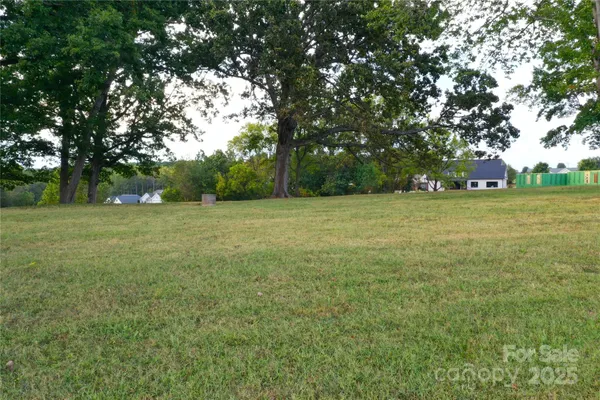 a view of a green field with trees in the background