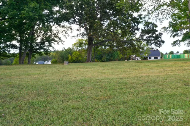 a view of a green field with trees in the background