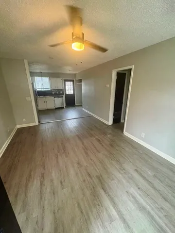 a view of empty room with wooden floor