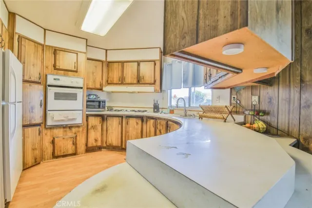 a view of a kitchen with kitchen island a large window cabinets and stainless steel appliances