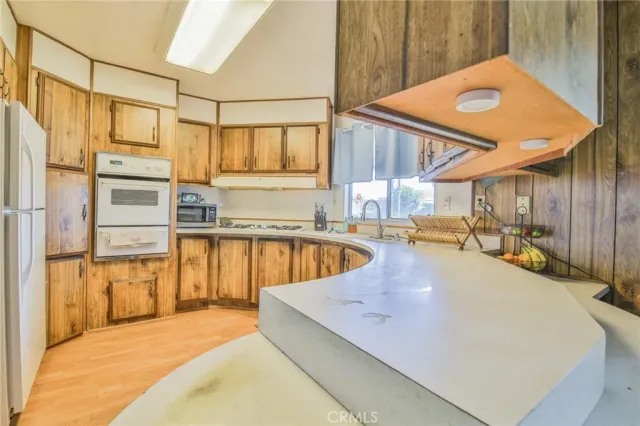a view of a kitchen with kitchen island a large window cabinets and stainless steel appliances