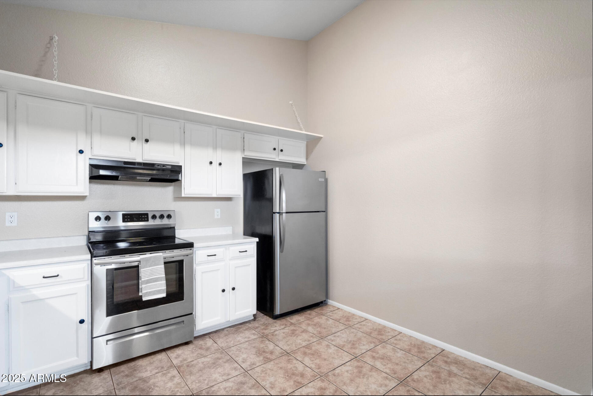 555 North May, Unit 23 Mesa, AZ 85201 - Photo 10 of 19 a kitchen with stainless steel appliances white cabinets and wooden floor