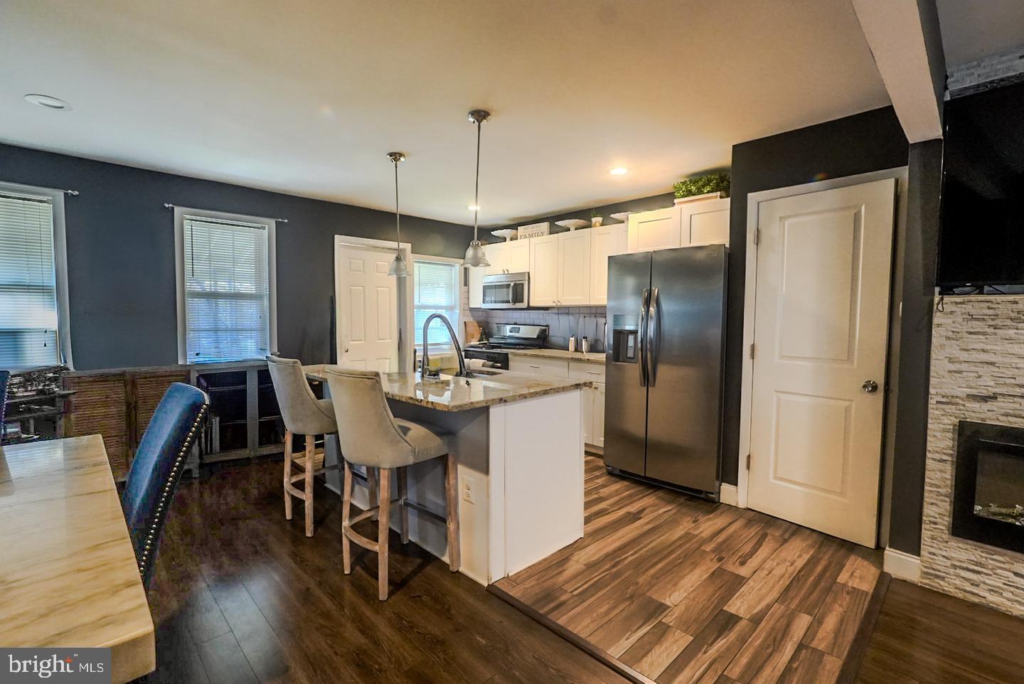 3915 Flowerton Road Baltimore, MD 21229 - Photo 2 of 15 a kitchen with refrigerator a sink dishwasher a dining table and chairs with wooden floor
