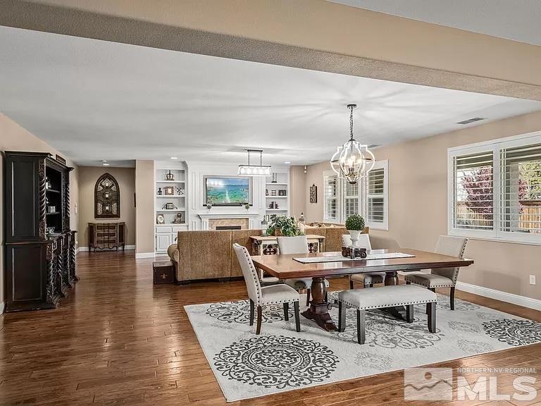 2725 Foxhunter Lane Reno, NV 89521 - Photo 3 of 25 a dining room with wooden floor a chandelier a wooden table and chairs