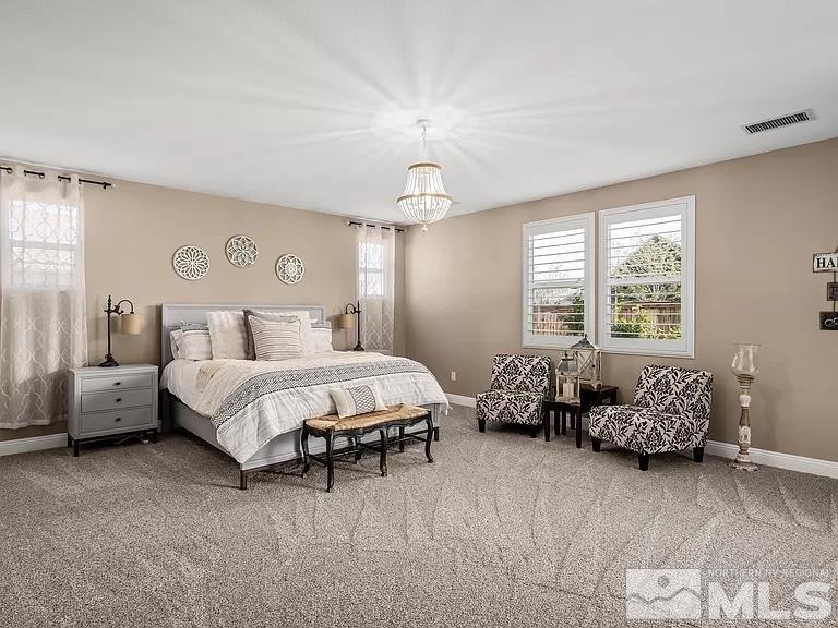 2725 Foxhunter Lane Reno, NV 89521 - Photo 8 of 25 a spacious bedroom with a bed and a chandelier