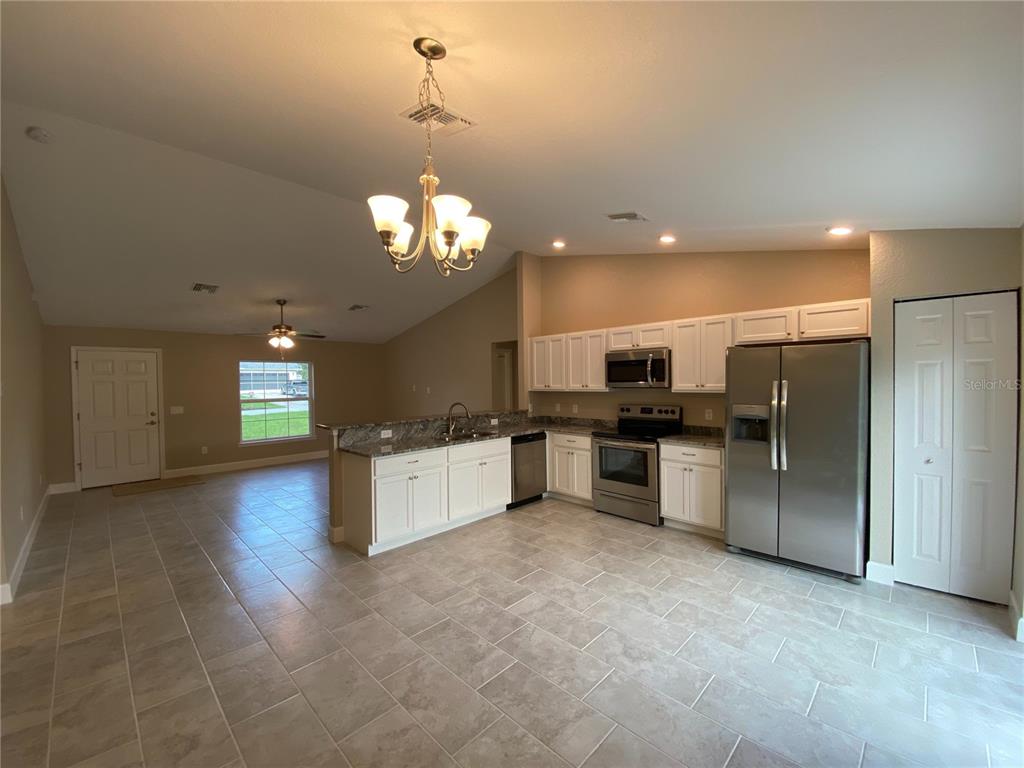 3011 Southwest 140th Loop Ocala, FL 34473 - Photo 4 of 22 a large kitchen with a refrigerator and a stove top oven