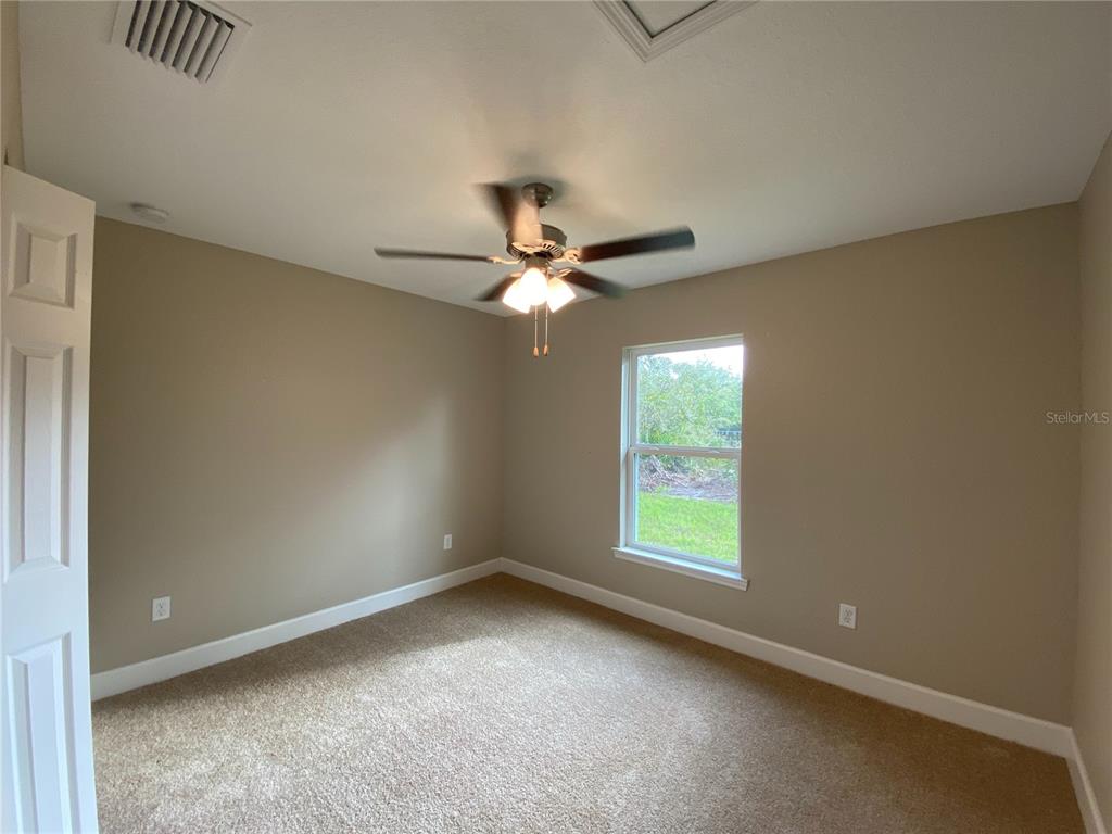 3011 Southwest 140th Loop Ocala, FL 34473 - Photo 9 of 22 an empty room with a window and a fan