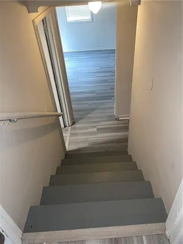 a view of staircase with white walls and railing