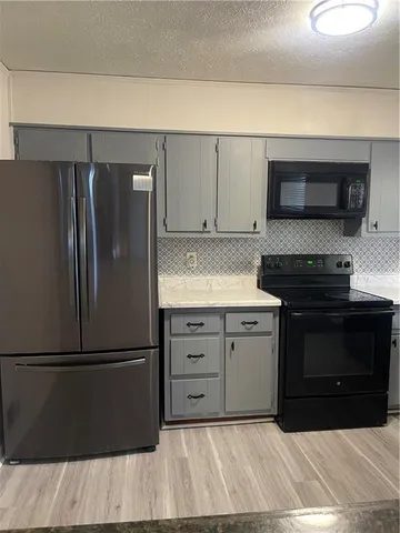 a kitchen with a refrigerator stove and cabinets