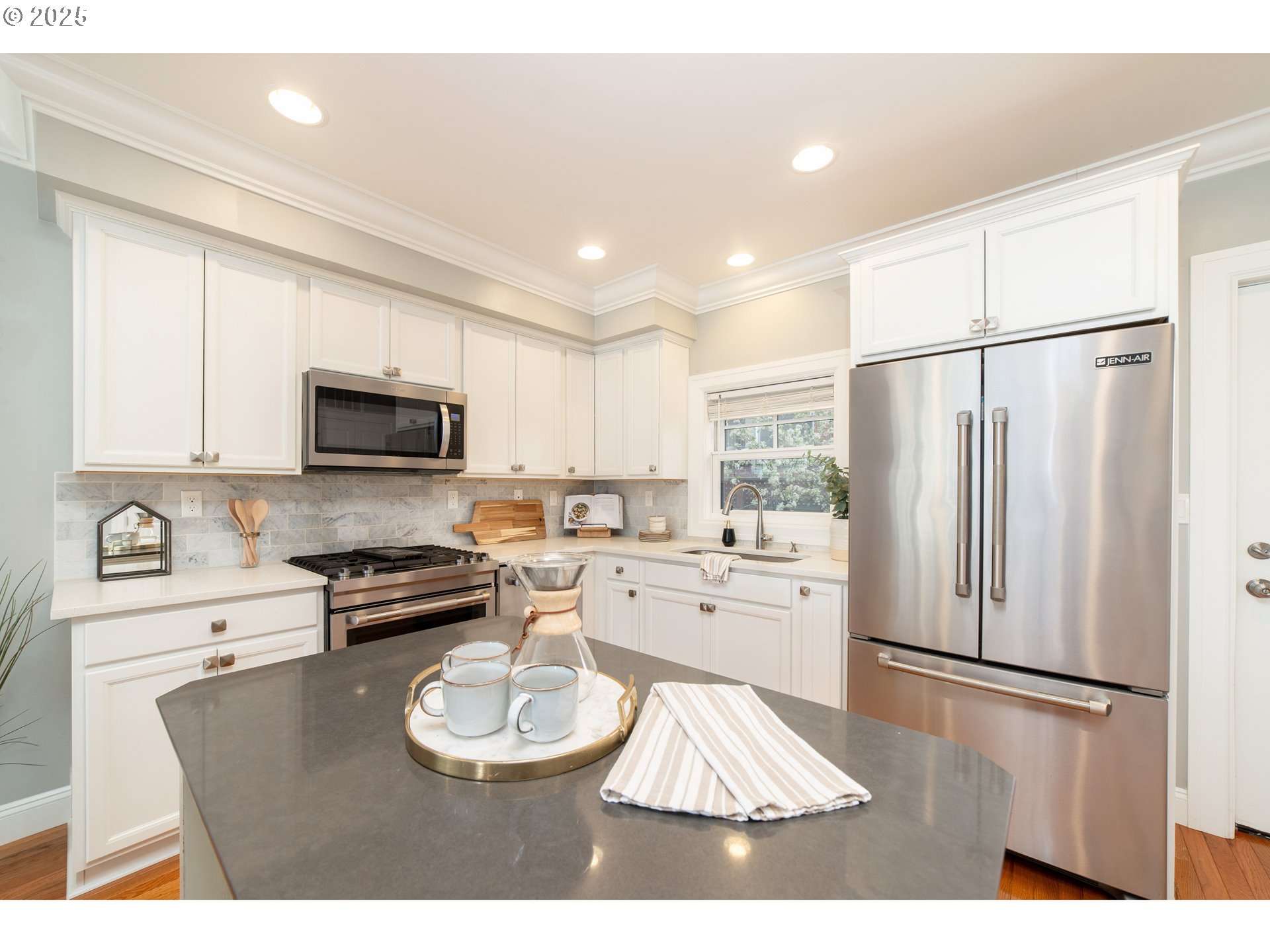 623 Northeast Randall Avenue Portland, OR 97232 - Photo 9 of 26 a kitchen with stainless steel appliances granite countertop a refrigerator a stove a sink a microwave and white cabinets with wooden floor