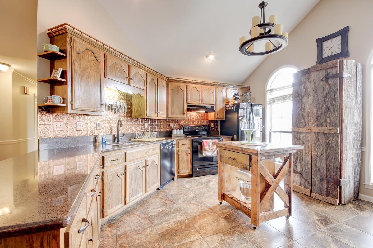 550 Hurricane Loop Tennessee Ridge, TN 37178 - Photo 7 of 18 a kitchen with stainless steel appliances granite countertop a refrigerator a sink dishwasher a stove and white cabinets with wooden floor