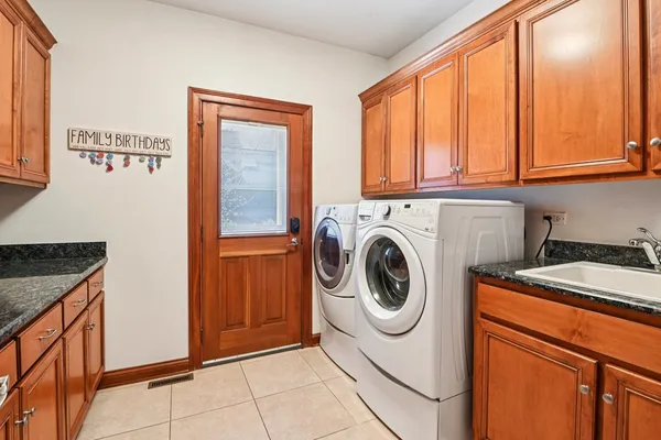an open kitchen with granite countertop a stove a sink dishwasher and a dining table with chairs