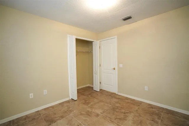 an empty room with closet and a bathroom