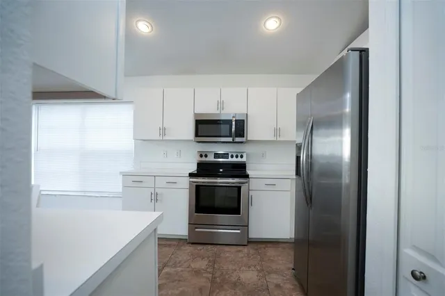 a kitchen with a refrigerator sink and cabinets