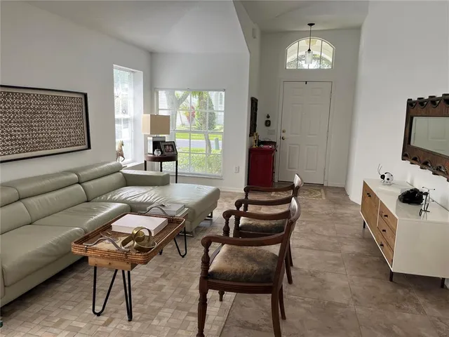 a living room with furniture a flat screen tv and a window