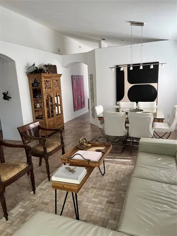 a view of a dining room with furniture and a chandelier