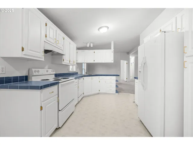 a kitchen with stainless steel appliances a refrigerator sink and cabinets